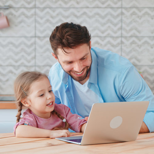 Young family with a child talking using a microphone and webcam in the kitchen